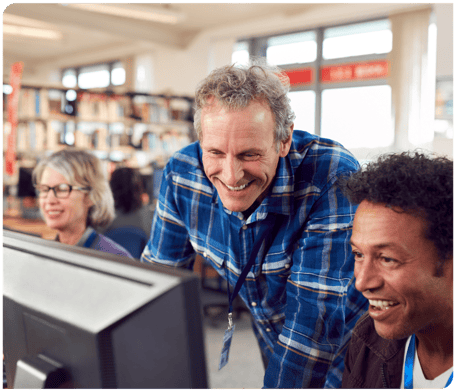 older man helps young man with his computer