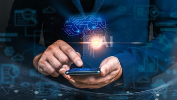 A man in a suit holds a smartphone displaying a brain icon, symbolizing technology and intelligence.